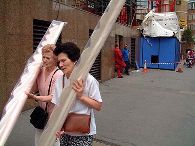 Two ladies carrying pelmets