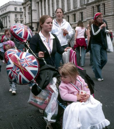 Union Jack balloons and a Sainsbury's bag, Woman pushing girl in buggy