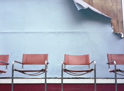 Empty chairs against a torn poster backdrop